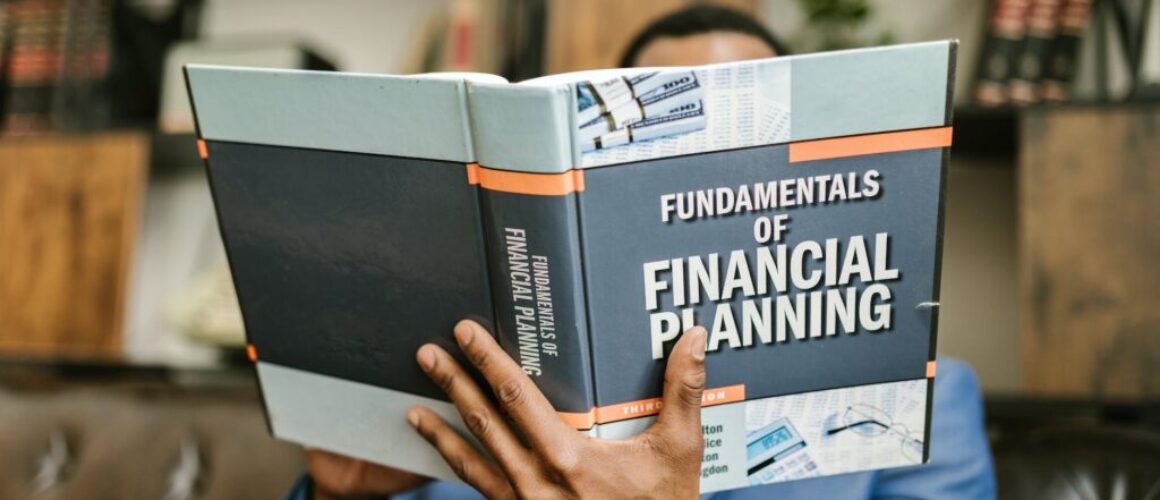 person reading a book about fundamentals of financial planning